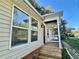 Exterior side view featuring the front porch, large windows, and the home's siding at 902 Estelle Ave, Brandon, FL 33511