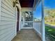Charming front porch with wood decking, white railing, and a red front door providing a welcoming entrance at 902 Estelle Ave, Brandon, FL 33511