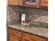 Close-up of the kitchen countertop featuring wooden cabinets, handles, and a granite countertop at 902 Estelle Ave, Brandon, FL 33511
