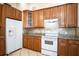 Kitchen featuring light-colored granite countertops, white appliances, and dark wooden cabinets at 902 Estelle Ave, Brandon, FL 33511