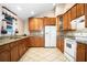 Kitchen area featuring light-colored granite countertops, wooden cabinets, and tile flooring at 902 Estelle Ave, Brandon, FL 33511