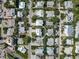 Aerial view of a neighborhood featuring homes with well-manicured landscaping and mature trees, centered on a blue house at 112 79Th St # B, Holmes Beach, FL 34217