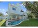 Backyard featuring a pool, lounge area, spiral staircase, and well-manicured lawn at 112 79Th St # B, Holmes Beach, FL 34217