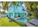 Lush backyard featuring lounge chairs, a pool, artificial turf, and a covered patio with turquoise pillars at 112 79Th St # B, Holmes Beach, FL 34217