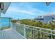 Balcony with white metal railing and lush tropical trees in the background at 112 79Th St # B, Holmes Beach, FL 34217
