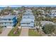 Two-story coastal home with a metal roof, a brick driveway, large garage, and a welcoming front porch at 112 79Th St # B, Holmes Beach, FL 34217