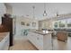 Bright, open kitchen featuring a central island with granite countertops and seating, seamlessly flowing into the living area at 112 79Th St # B, Holmes Beach, FL 34217