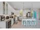 Modern kitchen with stainless steel appliances, white cabinetry, granite countertops, and an island with seating at 112 79Th St # B, Holmes Beach, FL 34217