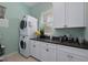 Laundry room featuring a stackable washer and dryer, granite countertops, and cabinets at 112 79Th St # B, Holmes Beach, FL 34217