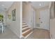 Bright foyer with beautiful wood-trimmed staircase and wood-look tile floors at 112 79Th St # B, Holmes Beach, FL 34217