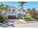 Beautiful two-story home featuring a red-tile roof, brick driveway, a balcony, and mature landscaping at 11320 E 6Th E St, Treasure Island, FL 33706