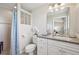 Bathroom with neutral vanity, framed mirror, tile floor, and a glass block window at 1145 Boundary Blvd, Rotonda West, FL 33947