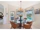 Bright breakfast nook with a glass table, wicker chairs, and a view of the outdoor pool area at 1145 Boundary Blvd, Rotonda West, FL 33947