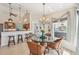 Bright breakfast nook featuring a chandelier, glass table, and a view of the patio with comfortable seating at 1145 Boundary Blvd, Rotonda West, FL 33947