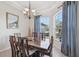 Cozy dining room featuring a wooden table, six chairs, and natural light from large windows at 1145 Boundary Blvd, Rotonda West, FL 33947