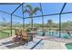 Screened-in lanai features a dining area with views of the serene backyard pond at 1145 Boundary Blvd, Rotonda West, FL 33947