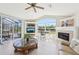 Bright living room featuring a fireplace, large windows, and sliding glass doors to a screened patio with a pool at 1145 Boundary Blvd, Rotonda West, FL 33947