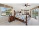 Bright main bedroom featuring a ceiling fan, large windows, and access to the outdoor pool at 1145 Boundary Blvd, Rotonda West, FL 33947
