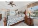 Sunlit main bedroom boasts a stylish bed with a ceiling fan and bright windows at 1145 Boundary Blvd, Rotonda West, FL 33947
