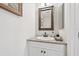 Neutral powder room with a granite vanity and rustic mirror at 1145 Boundary Blvd, Rotonda West, FL 33947