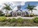 Beautiful clubhouse with a metal roof, lush landscaping, and classic color scheme in a tropical setting at 12857 Satin Lily Dr, Riverview, FL 33579