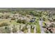 Picturesque aerial showcases a community with lush greenery and serene landscaping, a golf course, and a lake at 13247 Palmilla Cir, Dade City, FL 33525