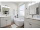 Bright bathroom featuring double sinks, a freestanding tub, and neutral finishes at 13247 Palmilla Cir, Dade City, FL 33525