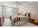 Bright bedroom features two twin beds, neutral walls, and a ceiling fan for added comfort at 13247 Palmilla Cir, Dade City, FL 33525