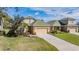 Charming home featuring a well-manicured lawn and driveway leading to attached garages at 13247 Palmilla Cir, Dade City, FL 33525