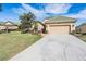 Inviting single-story home with a well-manicured lawn, a spacious driveway, and an attached two-car garage at 13247 Palmilla Cir, Dade City, FL 33525
