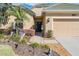 Inviting front entrance with green roof, well-maintained landscaping and a charming front door at 13247 Palmilla Cir, Dade City, FL 33525