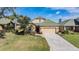 Beautiful single-Gathering home featuring lush landscaping, palm trees, and a two-car garage at 13247 Palmilla Cir, Dade City, FL 33525