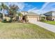 Charming single-Gathering home with a well-manicured lawn, palm trees, and a two-car garage at 13247 Palmilla Cir, Dade City, FL 33525