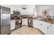 Well-lit kitchen featuring white cabinets, granite countertops, and stainless steel appliances at 13247 Palmilla Cir, Dade City, FL 33525