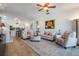 Bright living room featuring a ceiling fan, rug, and comfortable seating with a view into the kitchen at 13247 Palmilla Cir, Dade City, FL 33525