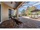 Spacious covered patio with brick flooring, comfortable seating, dining table, and a serene outdoor space at 13247 Palmilla Cir, Dade City, FL 33525