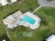 Aerial view of the community pool with many lounge chairs and tables surrounded by lush landscaping at 1375 Doolittle Ln # 103, Dunedin, FL 34698