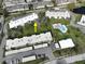 An aerial view showing the proximity of the swimming pool, common building and pond at 1375 Doolittle Ln # 103, Dunedin, FL 34698