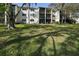 The exterior view of the building includes balconies and well-manicured landscaping at 1375 Doolittle Ln # 103, Dunedin, FL 34698