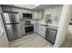 A remodeled kitchen featuring stainless appliances, granite countertops, and updated white and grey cabinets at 1375 Doolittle Ln # 103, Dunedin, FL 34698