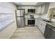 Updated kitchen features stainless appliances, new cabinetry, granite countertops, and wood-look tile flooring at 1375 Doolittle Ln # 103, Dunedin, FL 34698
