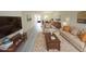 This staged living room features wood-look tile flooring and a comfortable seating arrangement at 1375 Doolittle Ln # 103, Dunedin, FL 34698