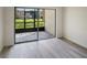 Screened-in patio with sliding glass doors overlooking the lush green grounds at 1375 Doolittle Ln # 103, Dunedin, FL 34698