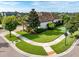 Aerial view of a home with lush landscaping, brick paver driveway, and a well-manicured lawn at 14315 Rolling Dune Rd, Lithia, FL 33547