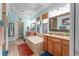 Luxurious bathroom with dual vanities, a soaking tub, and elegant tile work, with lots of lighting at 14315 Rolling Dune Rd, Lithia, FL 33547
