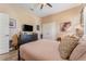 Bedroom featuring a bed with decorative pillows, a ceiling fan, and a wall-mounted TV at 14315 Rolling Dune Rd, Lithia, FL 33547