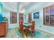 Bright dining room with a glass-top table, wood chairs, and natural light from multiple windows at 14315 Rolling Dune Rd, Lithia, FL 33547
