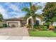 Inviting single-story home with a brick driveway, a two-car garage, and a beautifully landscaped front yard with lush greenery at 14315 Rolling Dune Rd, Lithia, FL 33547