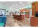 Open-concept kitchen features an island with barstool seating, wood cabinetry and pendant lighting at 14315 Rolling Dune Rd, Lithia, FL 33547
