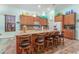Bright kitchen featuring granite countertops, wood cabinets, and barstool seating at the island at 14315 Rolling Dune Rd, Lithia, FL 33547